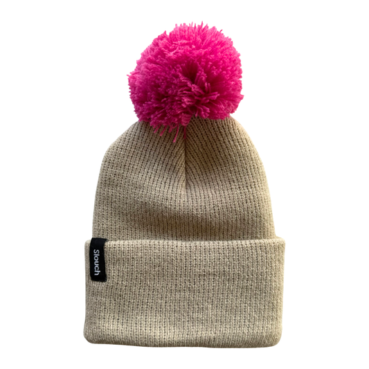 Beige knit beanie with a pink pom-pom on a white background